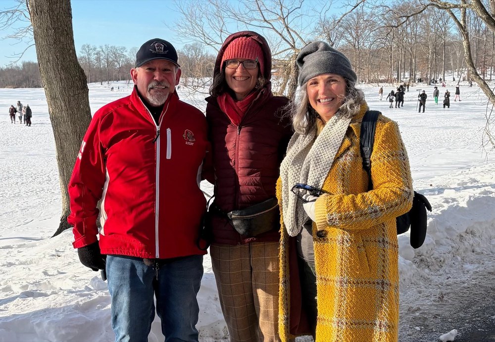 Gina DeFelice with two neighbors on a frozen lake on a winter afternoon